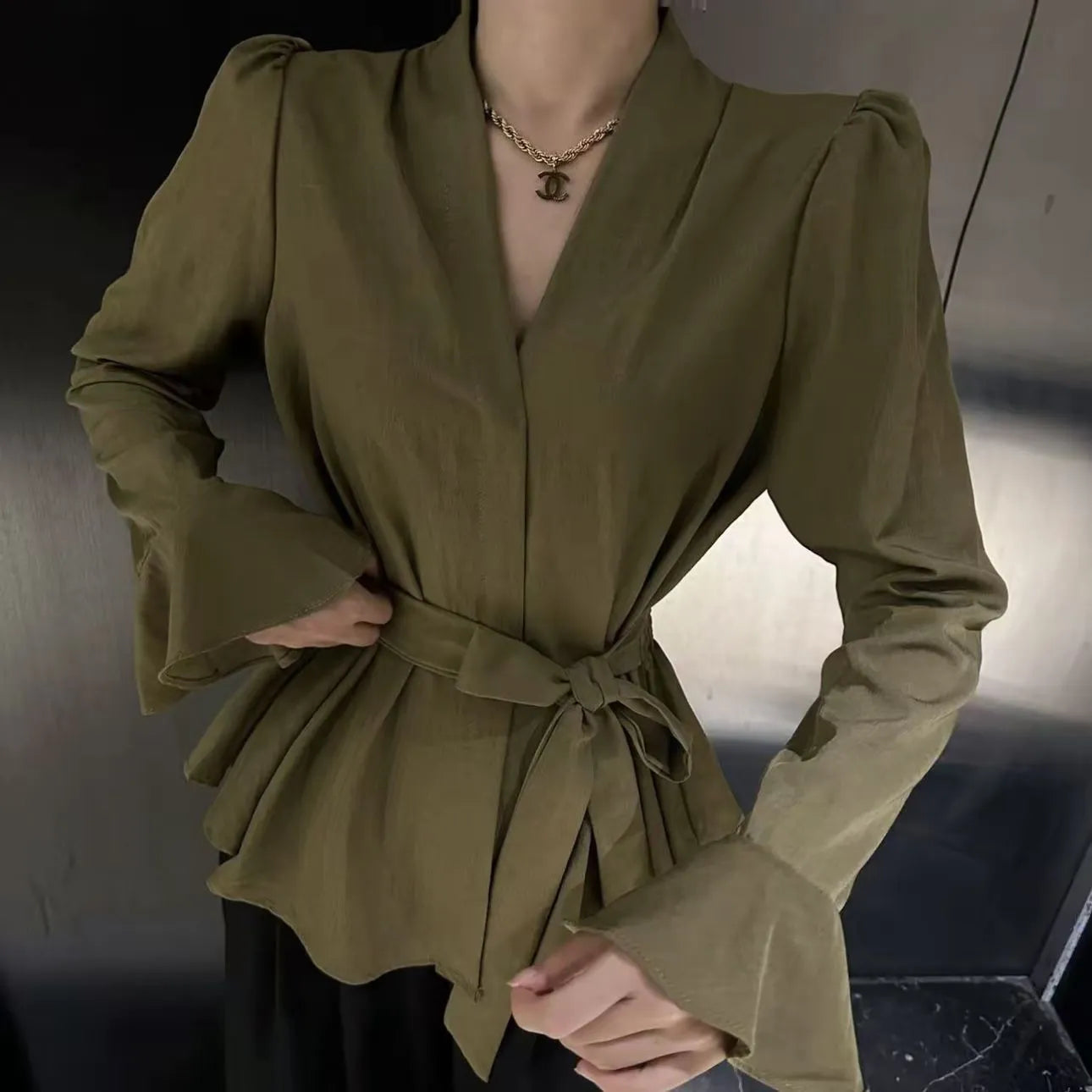 Women's black French-style shirt with irregular collar, long bell sleeves, and a tied front.