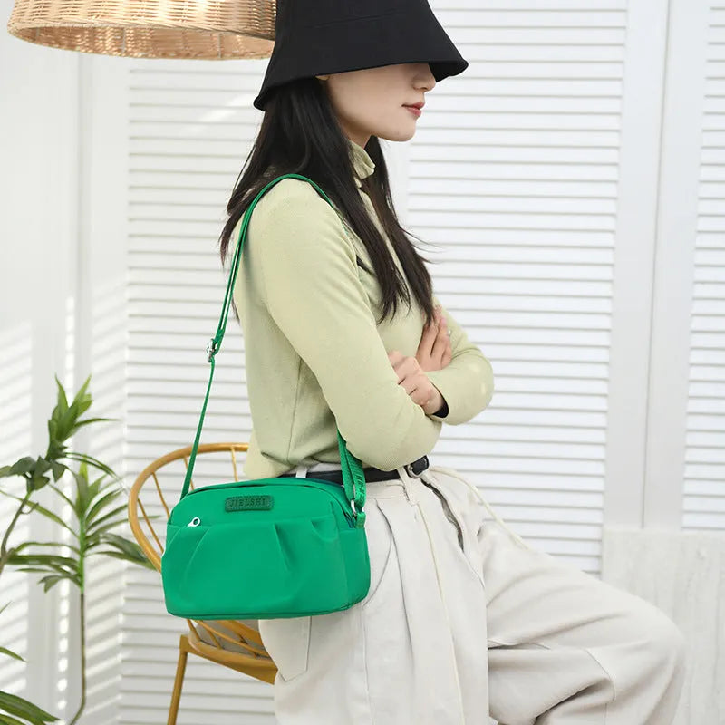 Pleated Oxford cloth crossbody messenger bag in a horizontal square shape with a phone compartment.