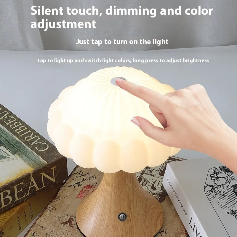 Small mushroom-shaped rechargeable night light in wood grain colour with touch control on desk.