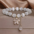 Women's white cat's eye crystal bracelet with flower tassel and morganite safety buckle.