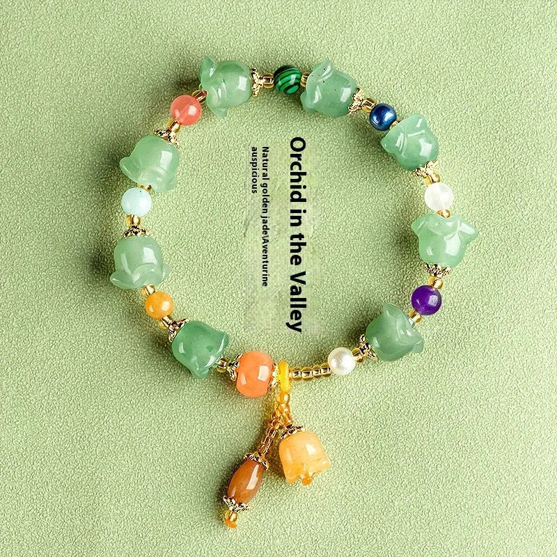 Close-up of a carved orchid bead jade bracelet in aventurine orchid colour on a wrist.