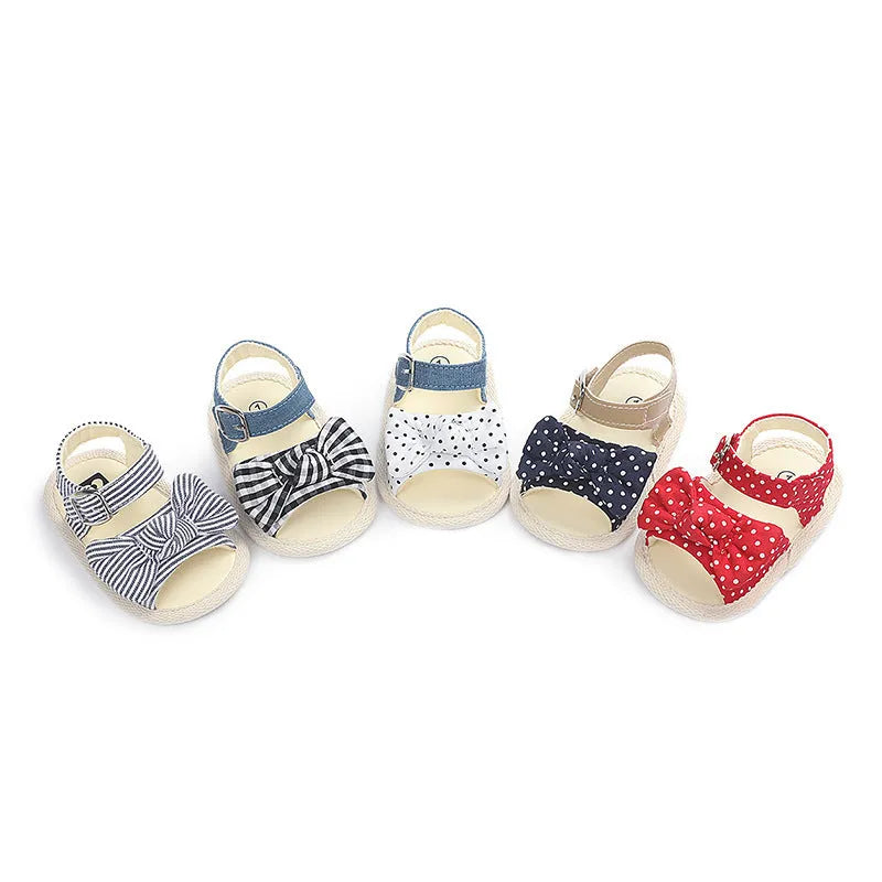 White and black toddler shoes with Velcro strap, showing low tube height design.