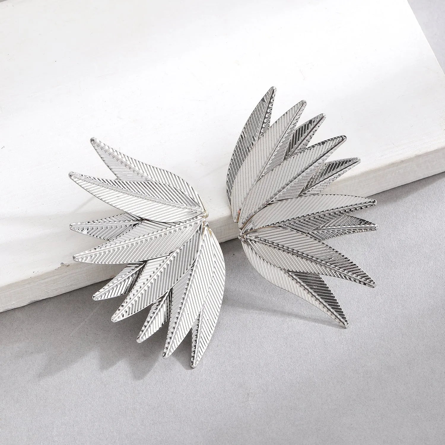 Gold and white leaf-shaped alloy patch earrings with botanical design details