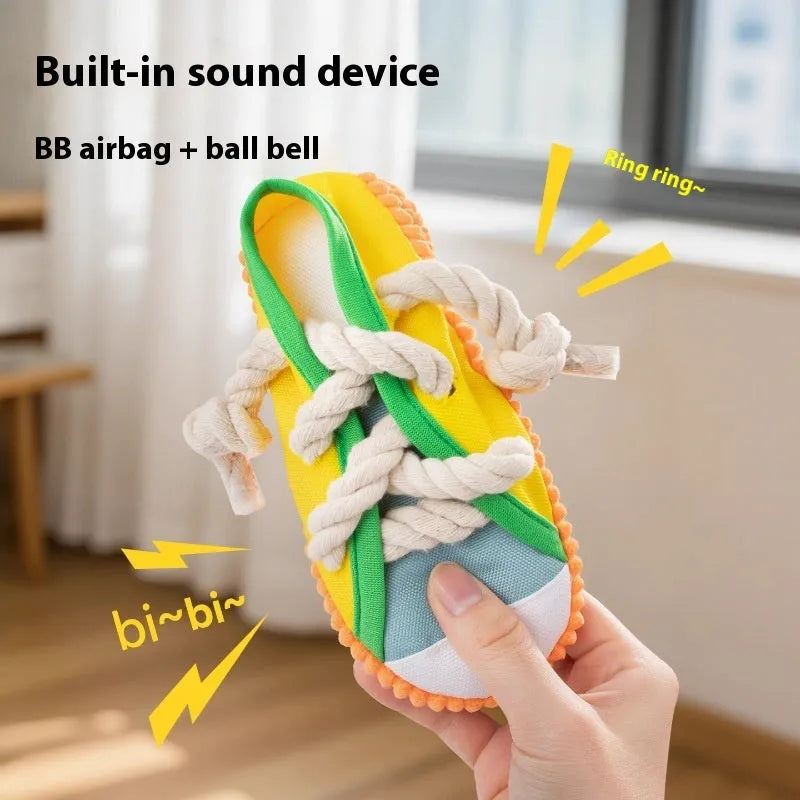 A rock yellow plastic dog chew toy shaped like a slipper, designed for biting and making sound.