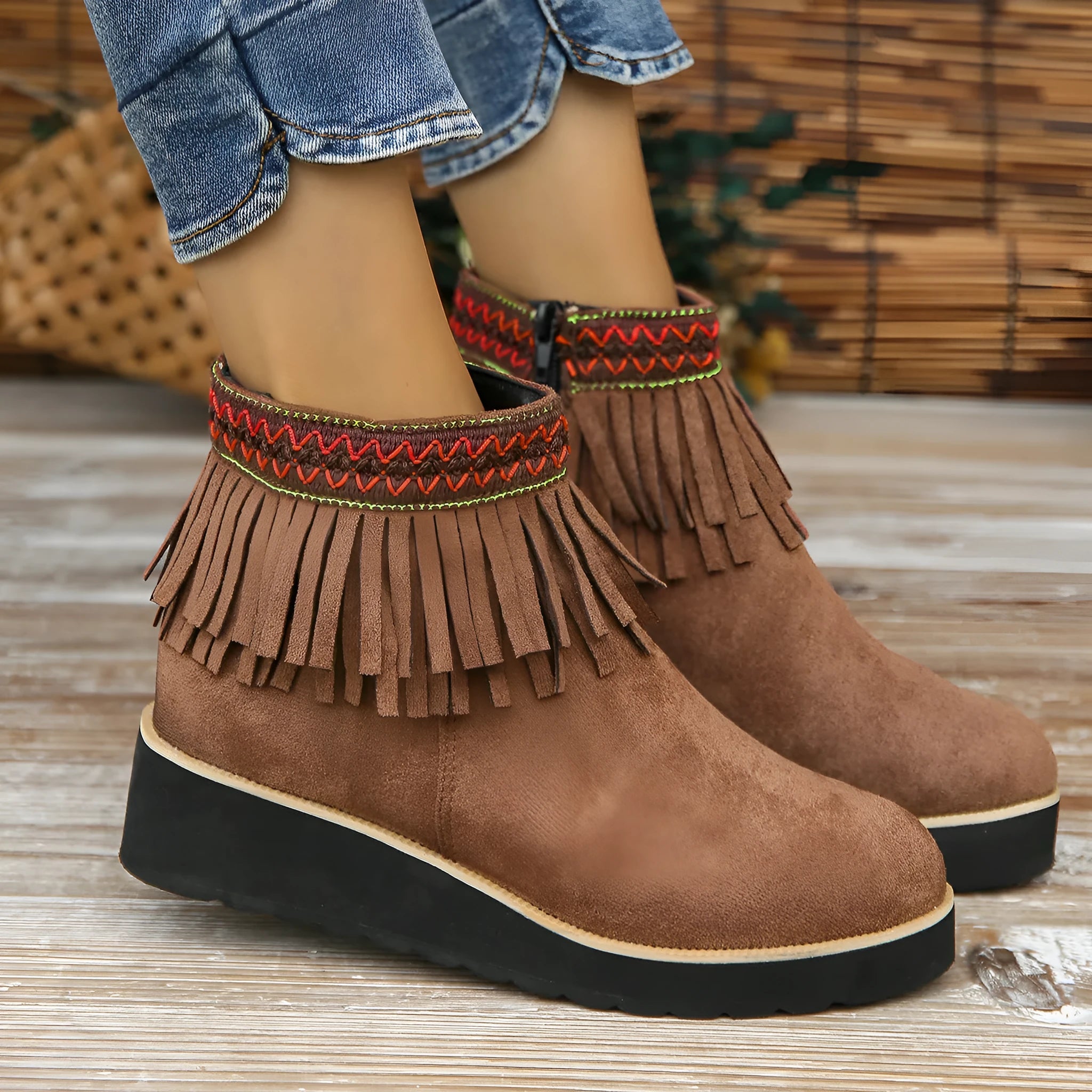 Women's dark brown suede wedge ankle boots with a side zipper and decorative tassels.