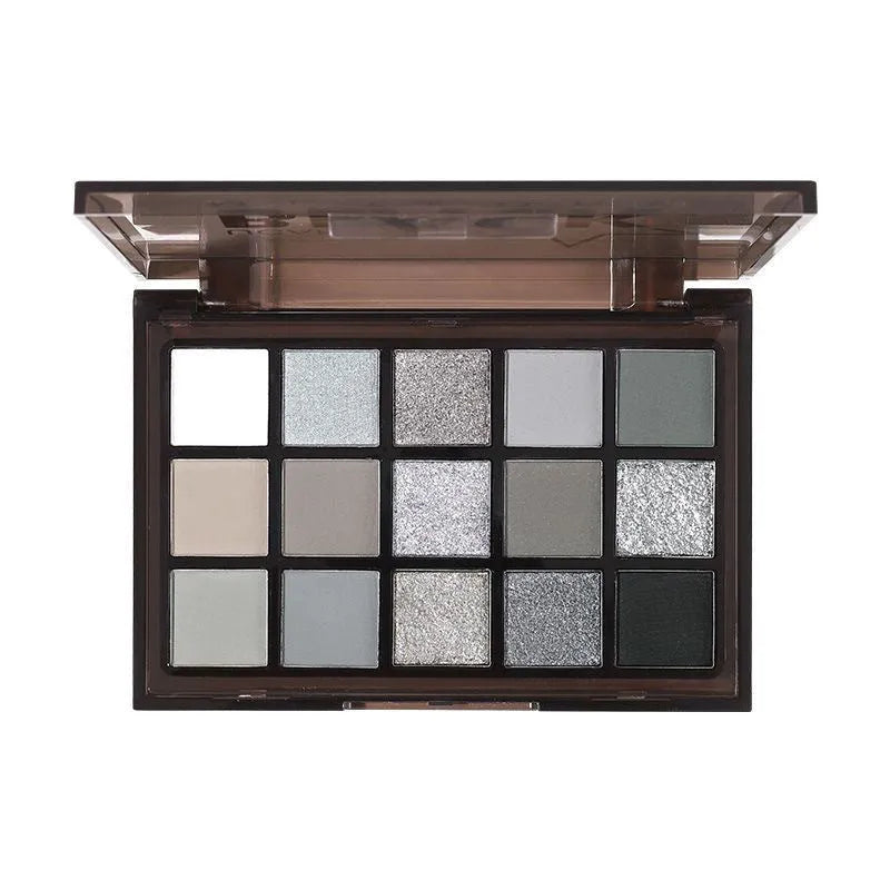 Open 15-pan eyeshadow palette showing matte and shimmer shades in browns, greys, blacks, and blues.