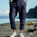 Men's solid colour linen casual trousers with ankle ties and multiple pockets in a loose fit.