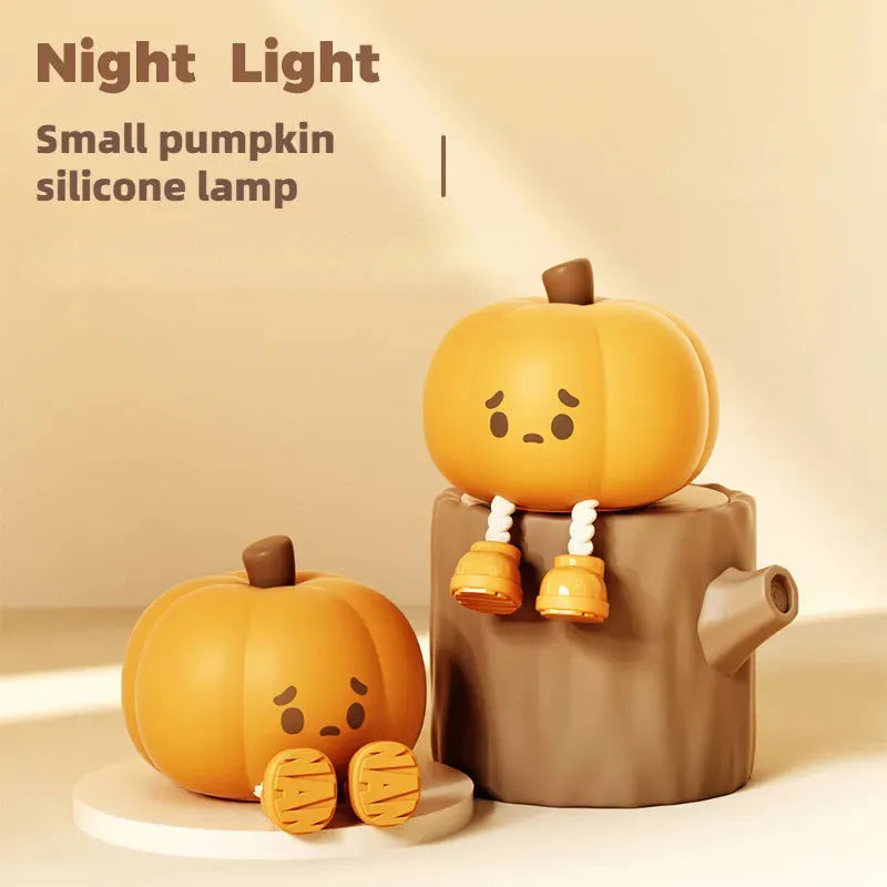Soft orange silicone pumpkin-shaped night light with a warm glow on a bedside table.