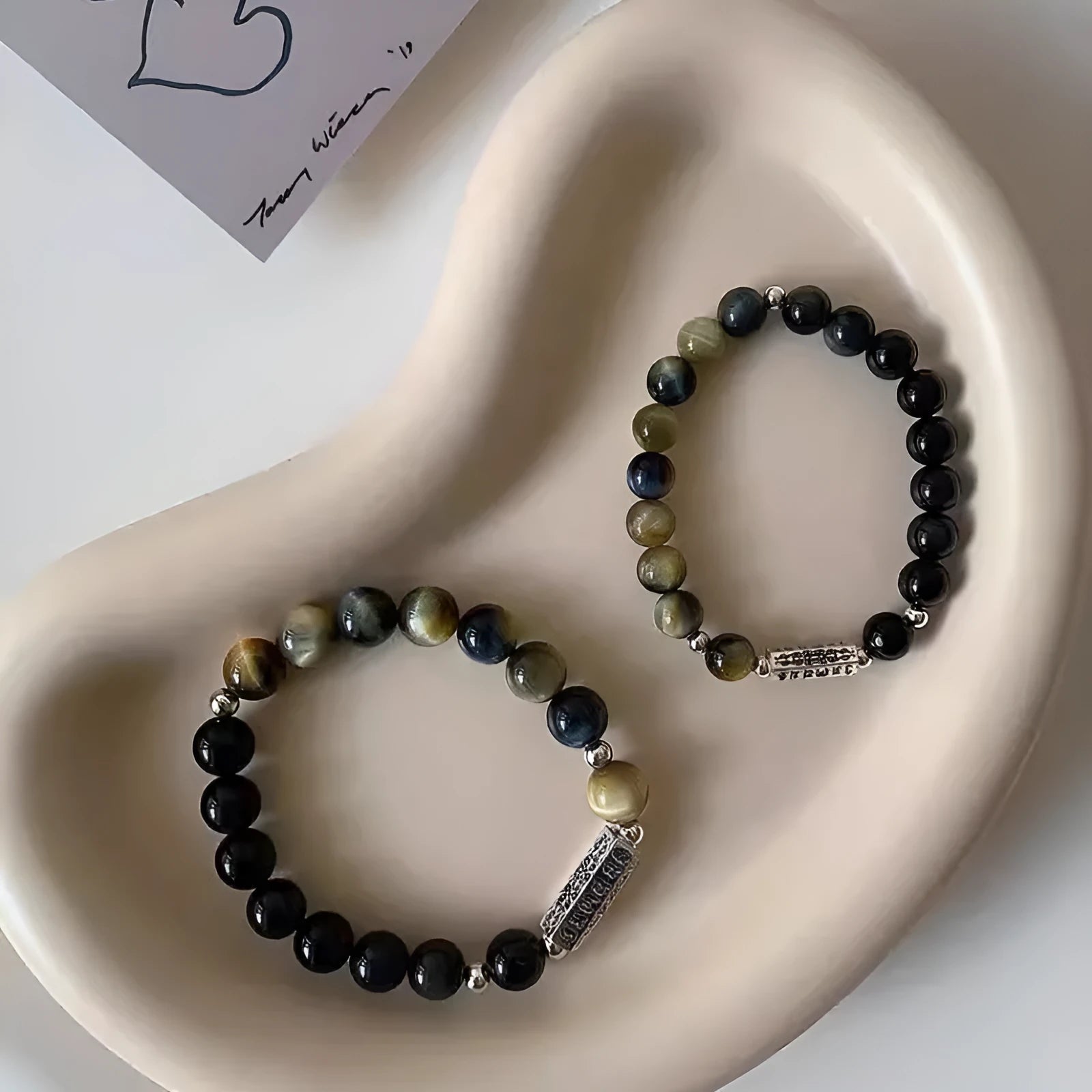 Sterling silver bracelet with obsidian and tigereye stone beads showing geometric round design and mantra engraving