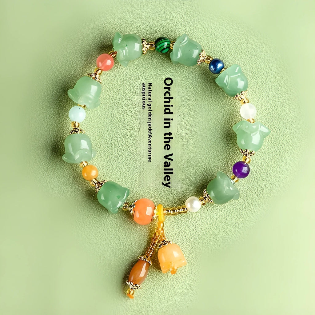 Close-up of a carved orchid bead jade bracelet in aventurine orchid colour on a wrist.