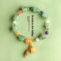 Close-up of a carved orchid bead jade bracelet in aventurine orchid colour on a wrist.