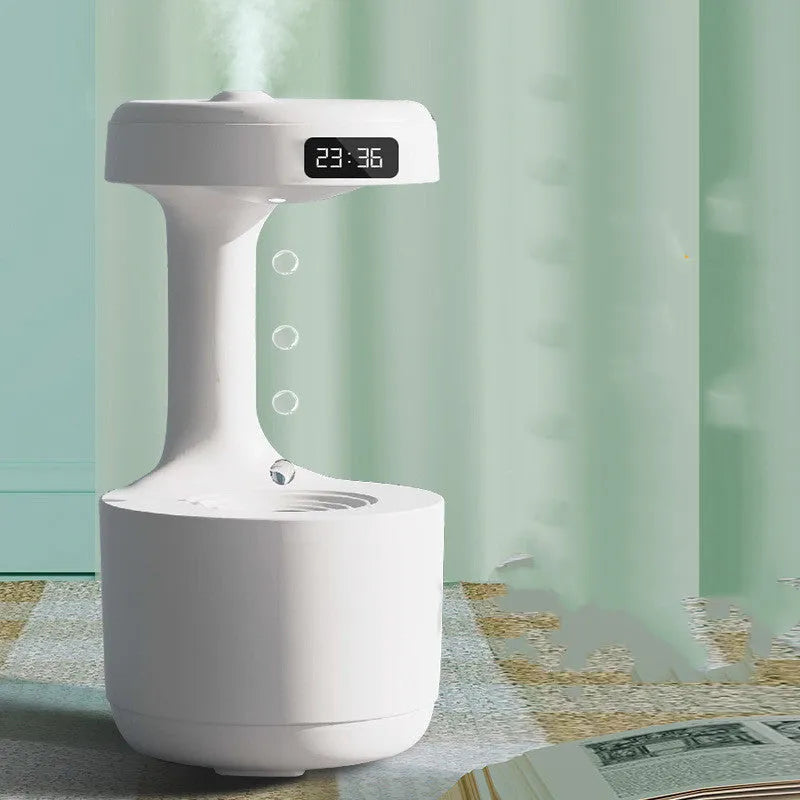 White columnar anti-gravity humidifier with LED clock display emitting mist on a wooden desk.