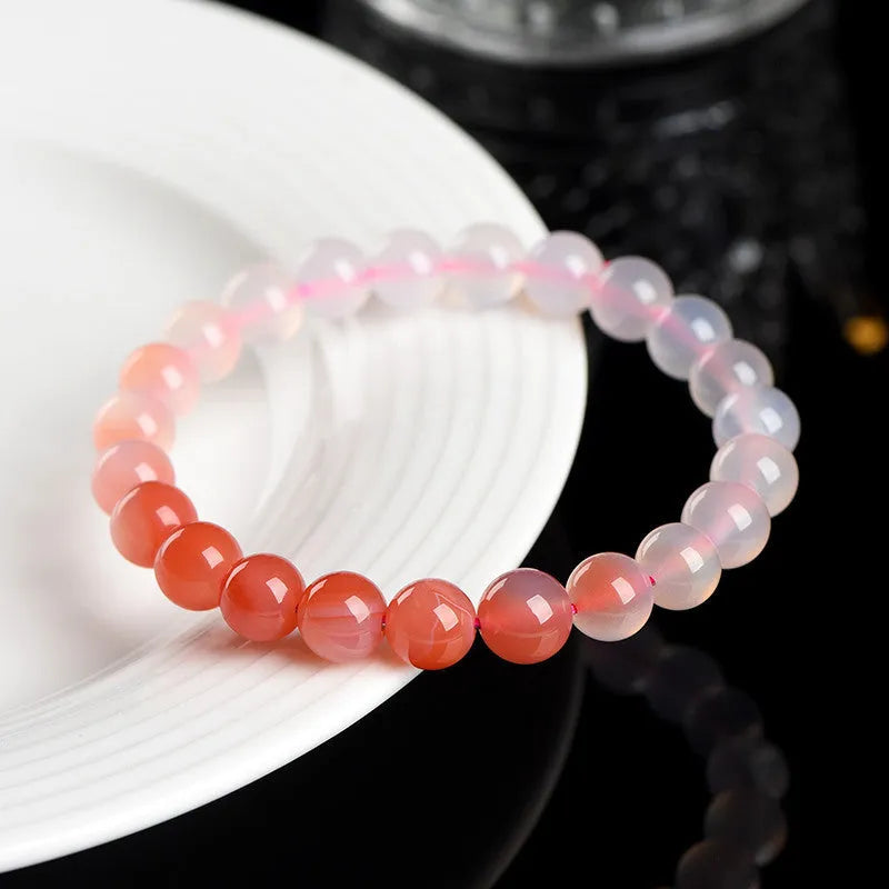 Natural gradient Yanyuan agate bracelet with geometric beads on a wrist.