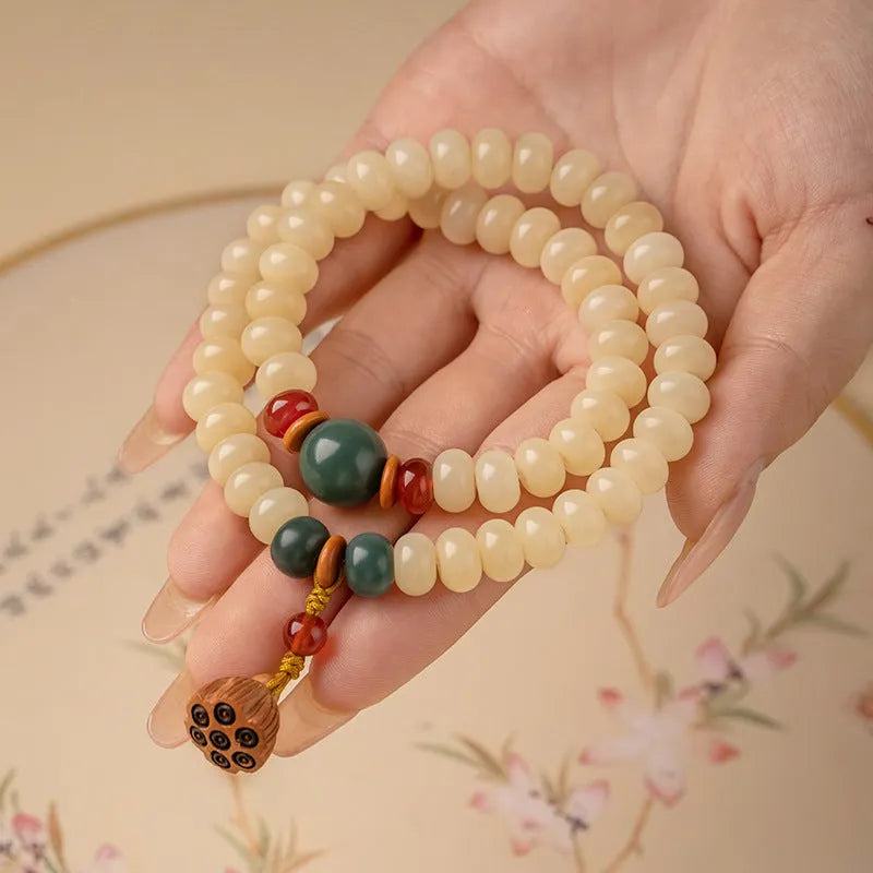 Cream topaz wooden bodhi root bracelet with flat round beads on a wrist.