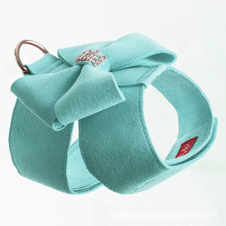 A pink microfiber dog chest strap with a large decorative bowknot and metal buckle.