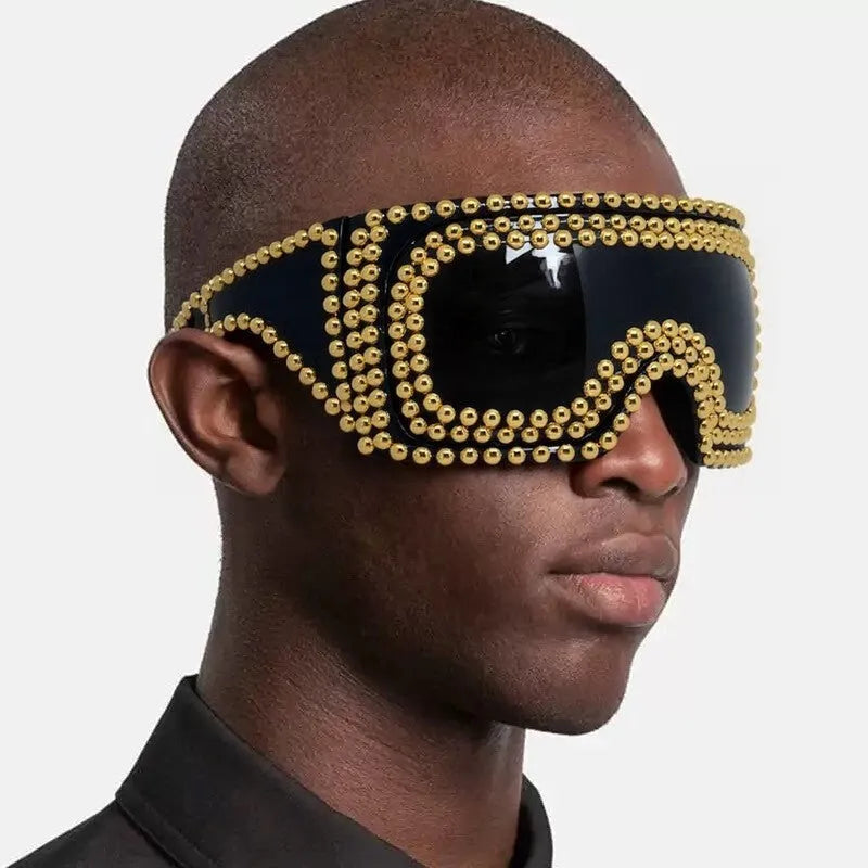 Men's square punk sunglasses with large rim and silver rivets on a dark background.