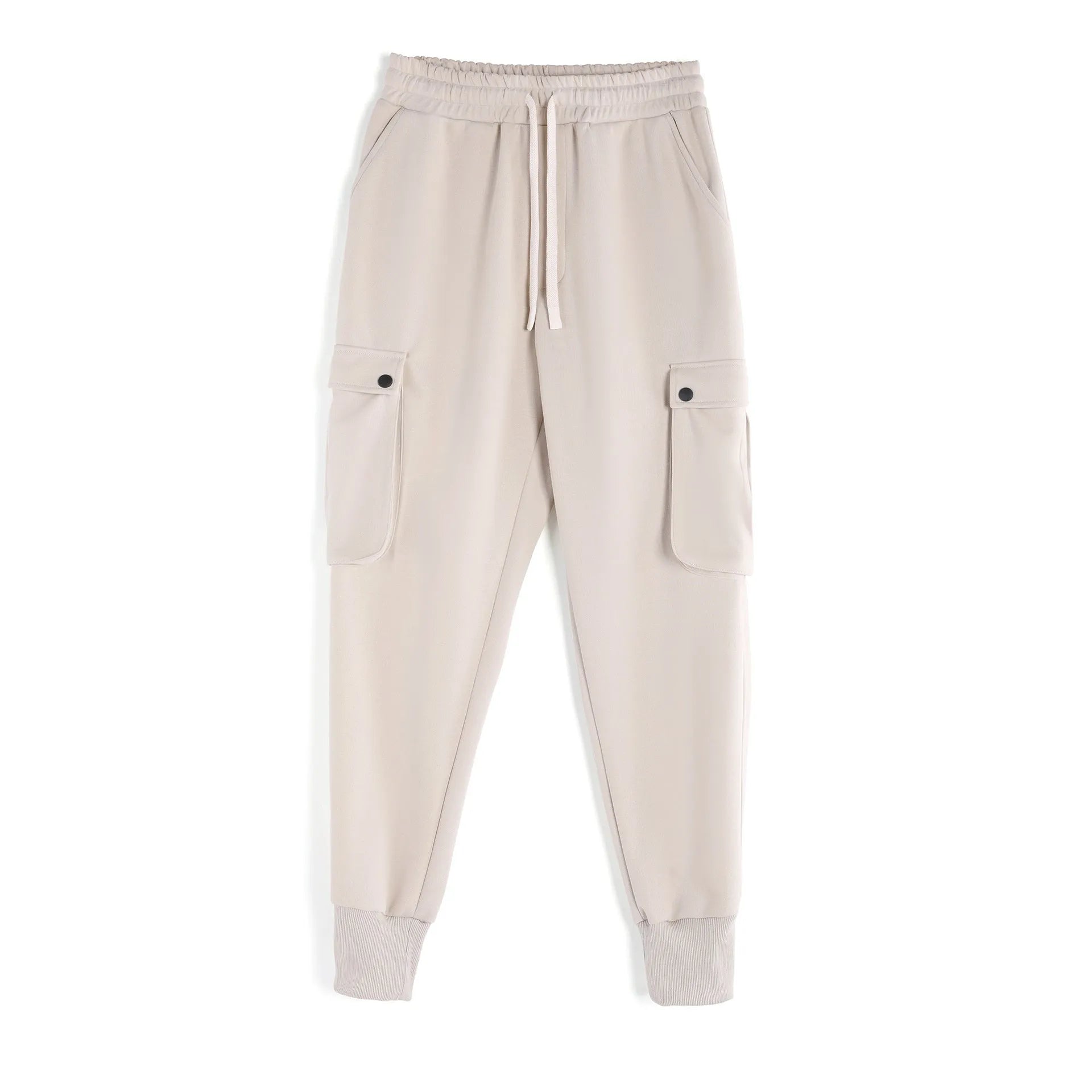 Man wearing loose light grey cotton trousers with ankle-tied cuffs and multiple pockets.