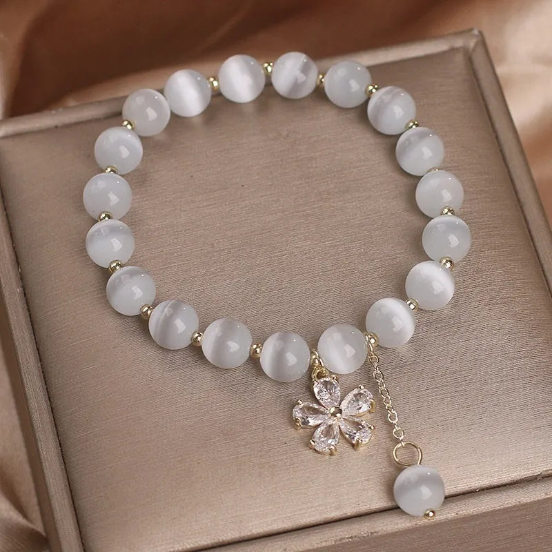 Women's white cat's eye crystal bracelet with flower tassel and morganite safety buckle.