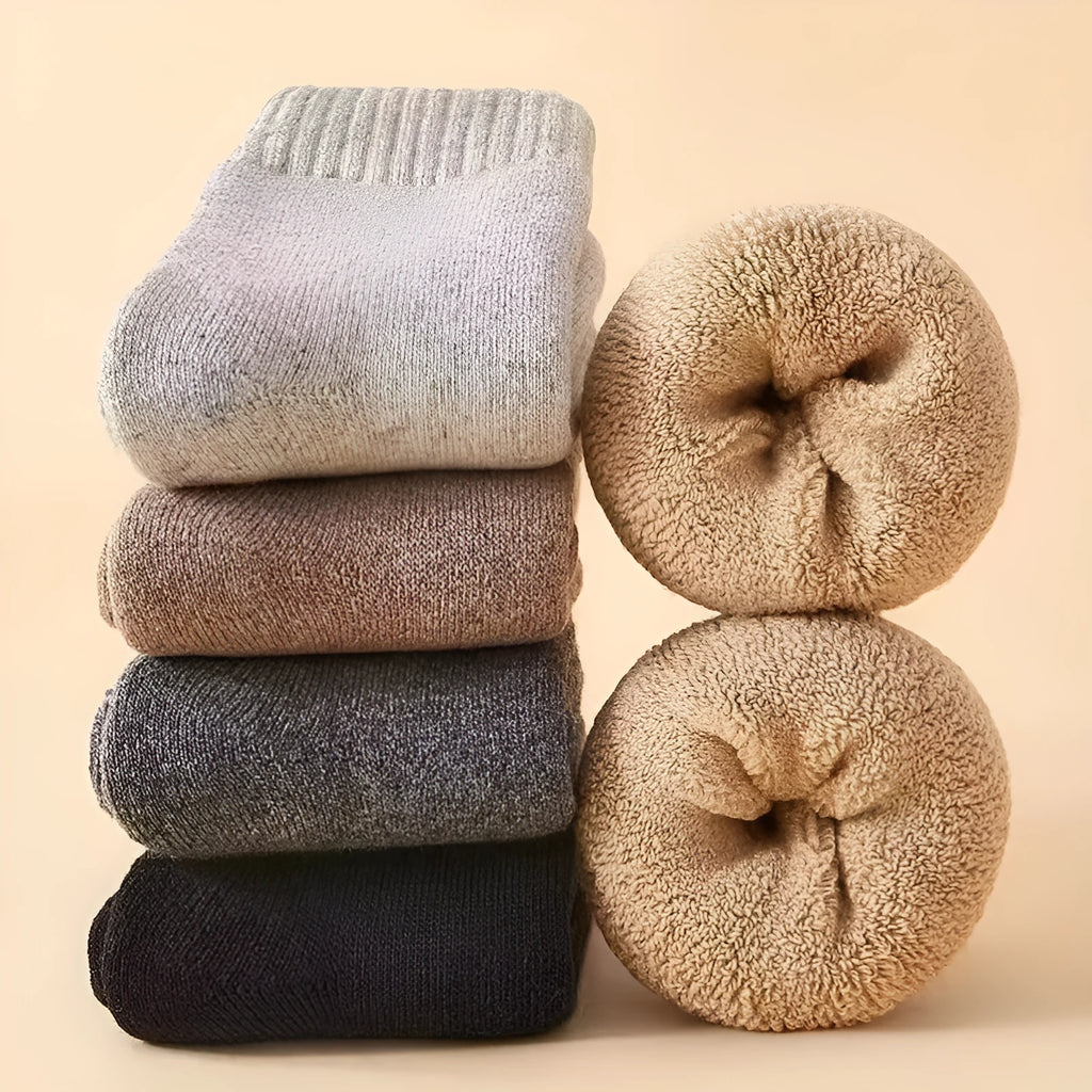 Two pairs of thick grey and black merino winter ankle socks with a thick midsole on a presentation box.