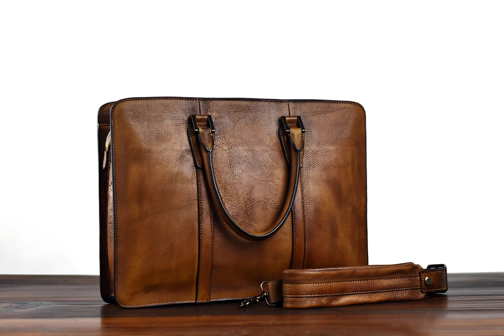 Men's brown leather horizontal business handbag with zippered closure on wooden surface