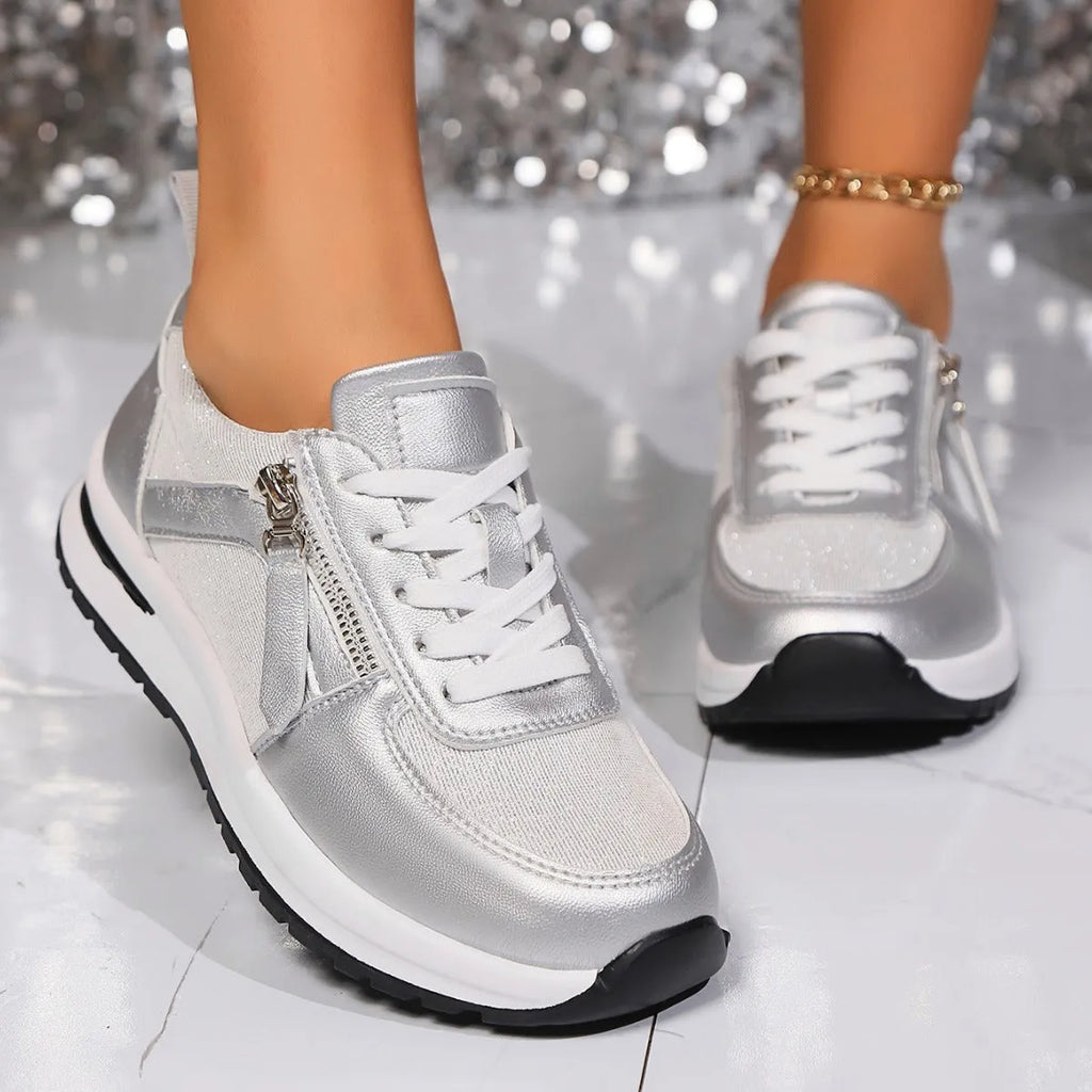 Gold women's flat lace-up pumps with round toe and rubber sole on a white background.