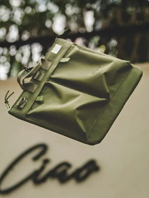 Military green canvas crossbody messenger bag with shoulder strap showing vertical square shape and zipper closure