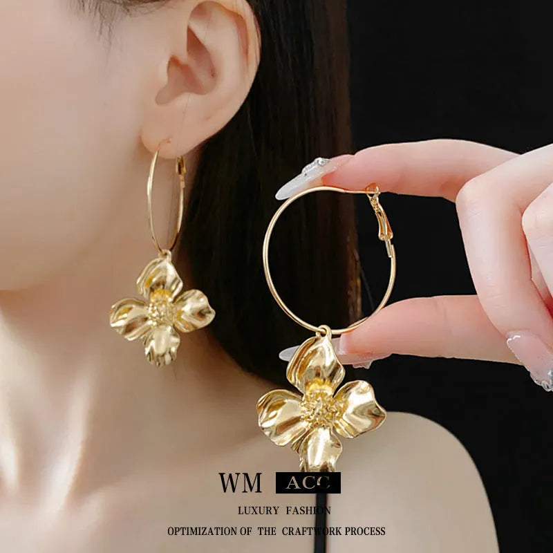 Geometric metal flower earrings with silver needle detail in gold or silver electroplated finish.