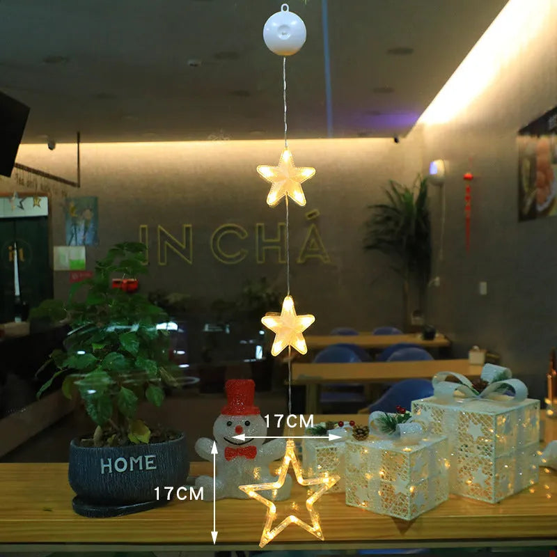 Three Christmas LED light ornaments with suction cups hanging on window
