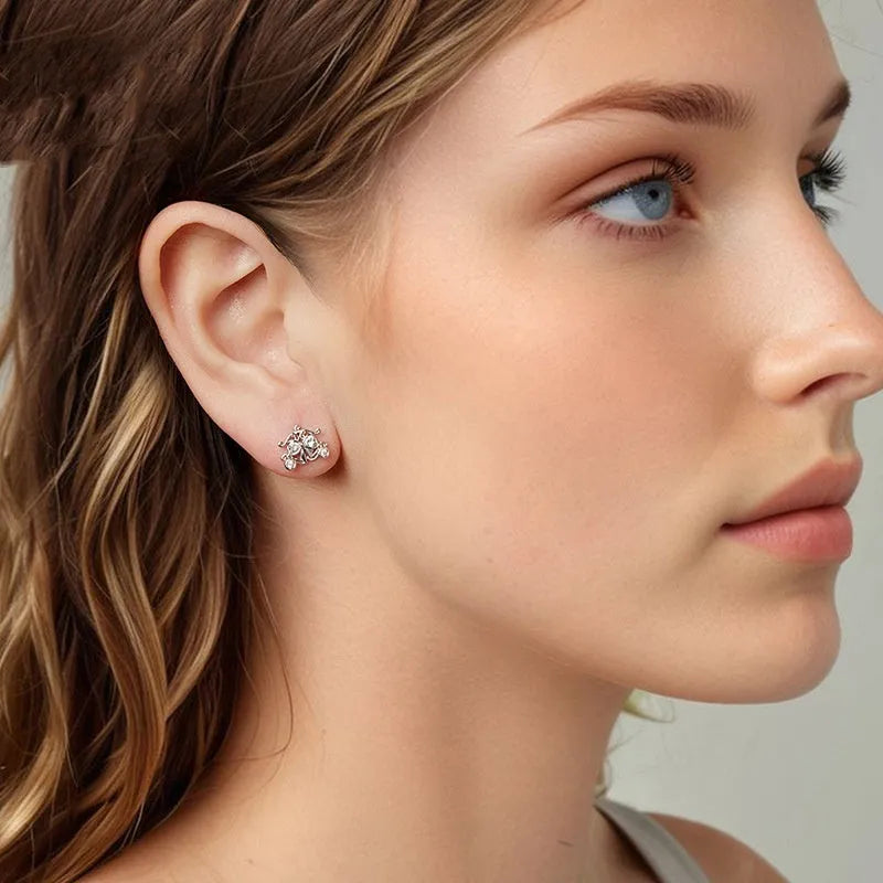 Pair of 925 silver retro pumpkin car stud earrings with romantic French design against a neutral background