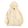 Man wearing a beige heavyweight zip-up hooded sweater, showing top-stitched pockets and loose fit.