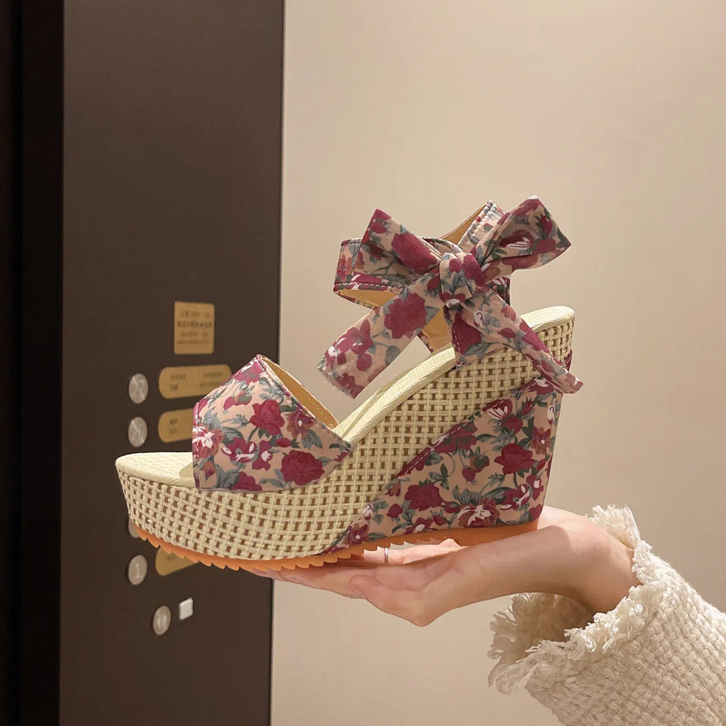Women's floral patterned peep toe wedge sandals with an ankle strap buckle.
