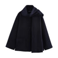 Women's long grey overcoat with artificial fur collar and pockets on a street-style backdrop.