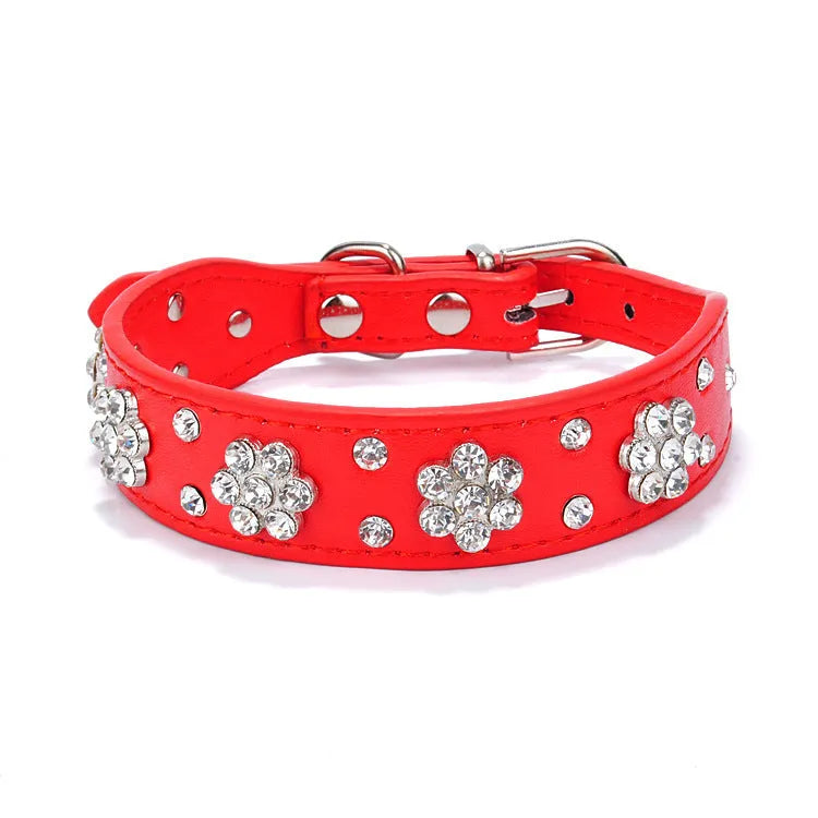 Close-up of a decorative black dog collar with sparkling rhinestone flowers and studs on PU leather.