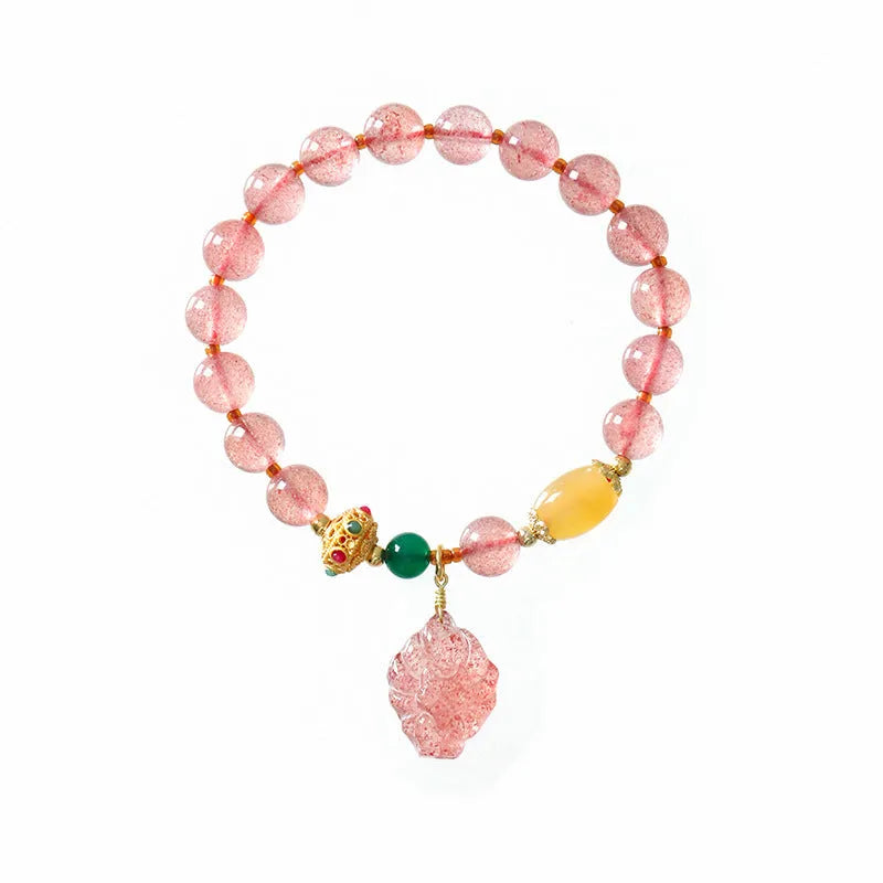 Women's crystal beaded bracelet with a strawberry quartz nine tail fox charm on a white background.