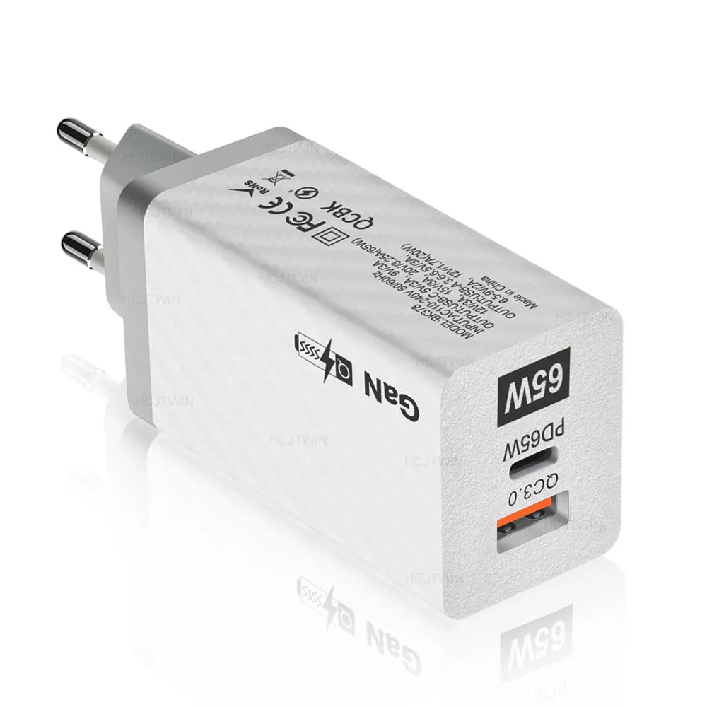 Compact white 65W Gallium Nitride laptop charger with USB-C port next to EU and US plug options.