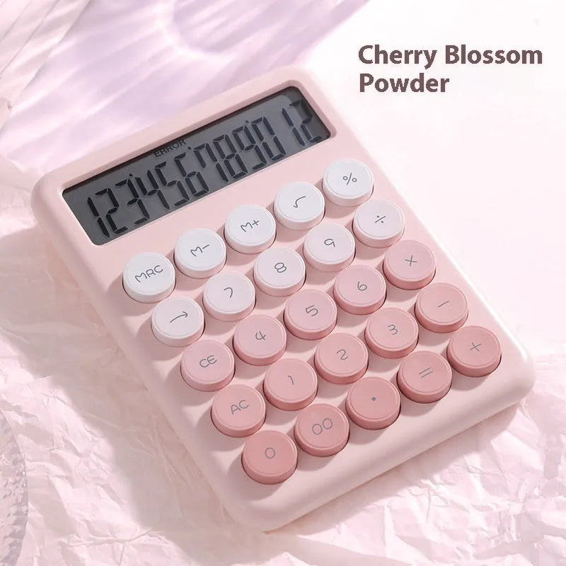 12-digit gradient colour desktop calculator in violet, blue, green, or pink on a desk