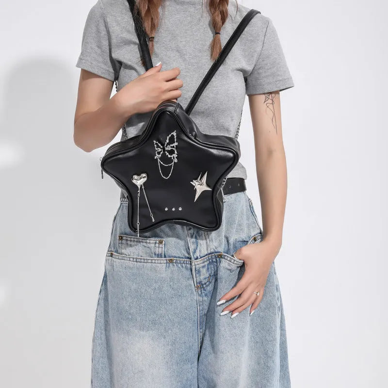 Black PU leather backpack with metal butterfly pendant and chain accents showing three-dimensional pockets