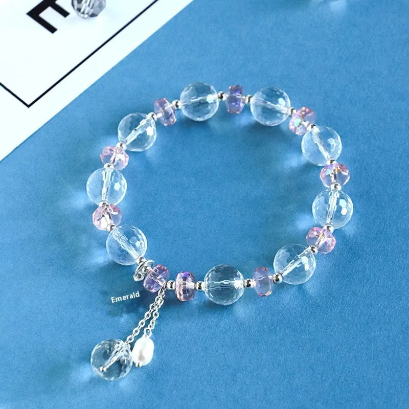 Women's white crystal bracelet with diamond shapes and lucky cat charm on wrist