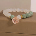 Jade floral bracelet with white agate jadeite stone and pink flower details on wrist