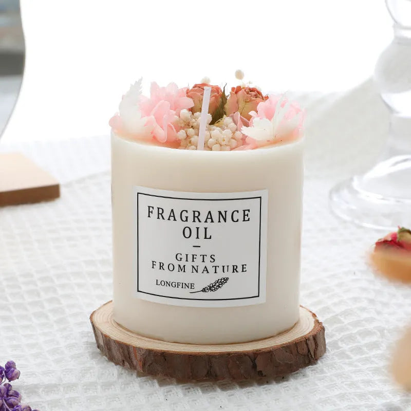 Decorative aromatherapy candle with dried flowers on surface, shown in gift box with chip base.