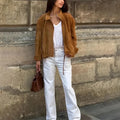 Man's solid colour retro loose-fit polyester jacket with long sleeves on a hanger.