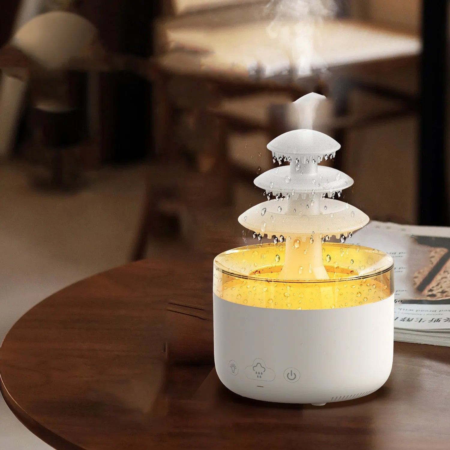 White cloud-shaped USB humidifier and essential oil diffuser with colourful mood lights on a wooden table.