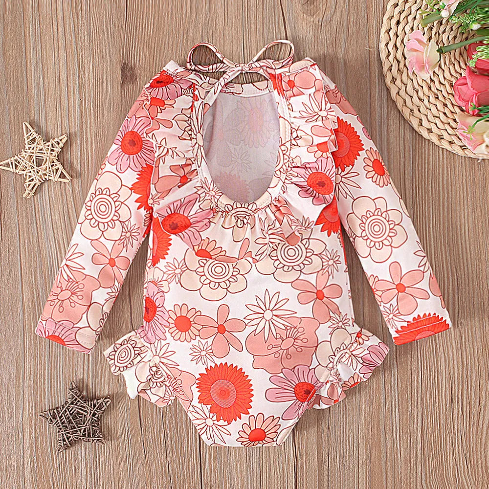 Girl's floral print swimsuit with crew neck and open back in orange red colour.