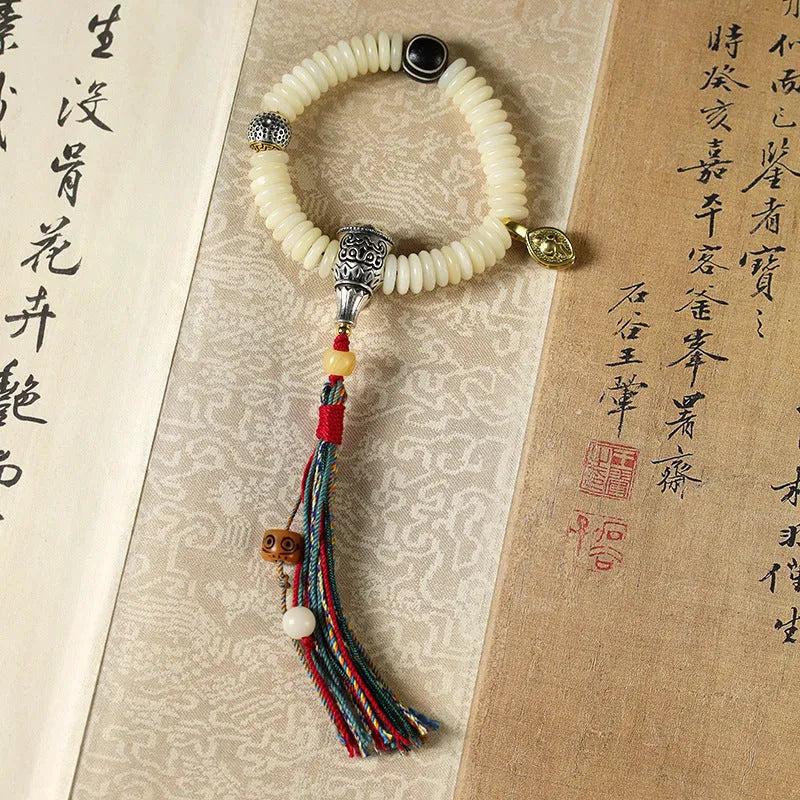 A white Bodhi seed bracelet shown in both a looped wrist style and a straight handheld style.