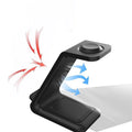 Black and white 3-in-1 upright wireless phone charger stand on a desk.