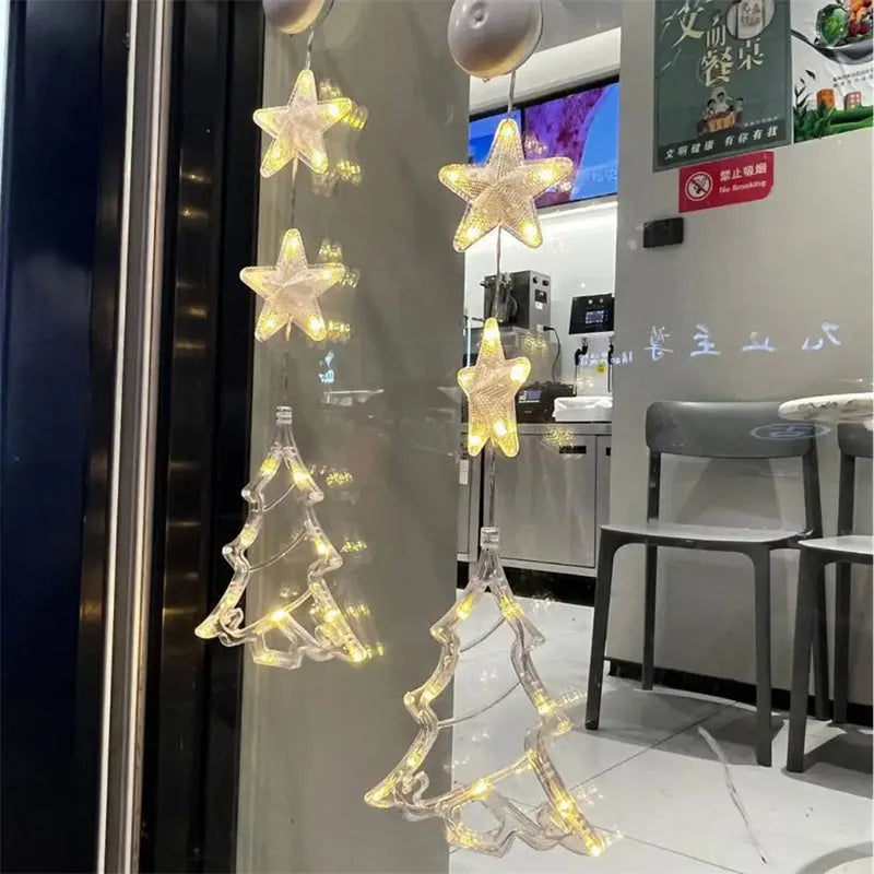 Three Christmas LED light ornaments with suction cups hanging on window