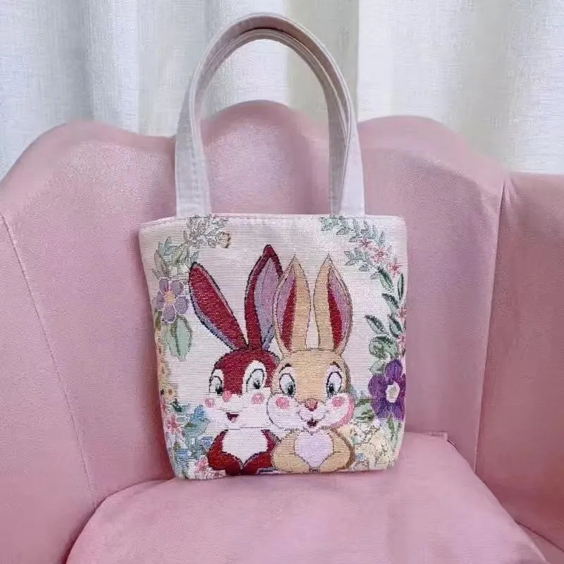 Double-sided gold wire embroidered canvas handheld bag in a floral design with polyester lining.