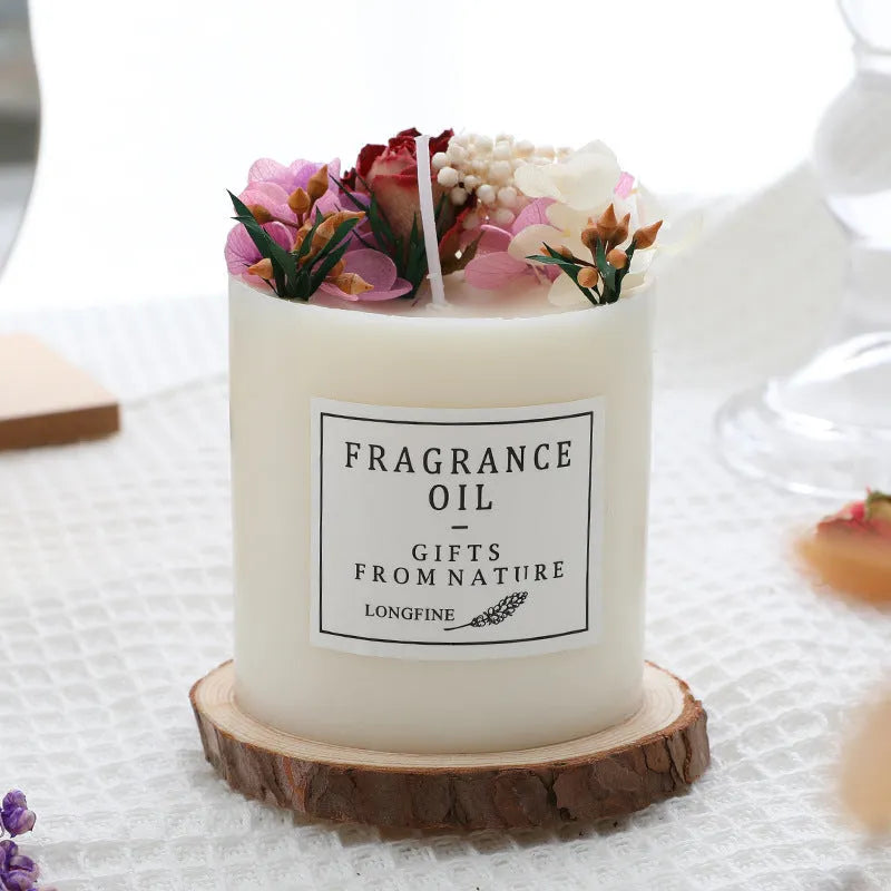 Decorative aromatherapy candle with dried flowers on surface, shown in gift box with chip base.