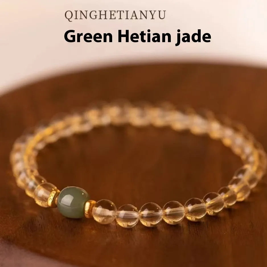 Close-up of a rutilated quartz bracelet showing gold rutile needles within green stone beads.