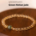 Close-up of a rutilated quartz bracelet showing gold rutile needles within green stone beads.